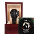 Black wristwatch in a wooden box with a Christmas card featuring a couple's silhouette.