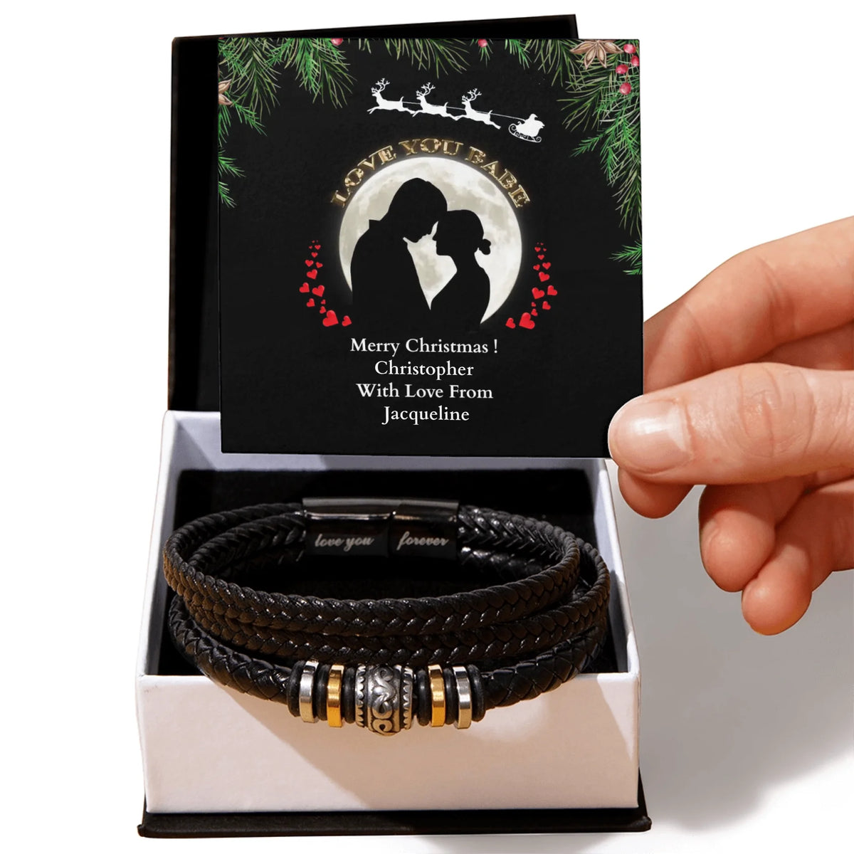 Black leather bracelet with metal charms in a decorative box with a personalized card.