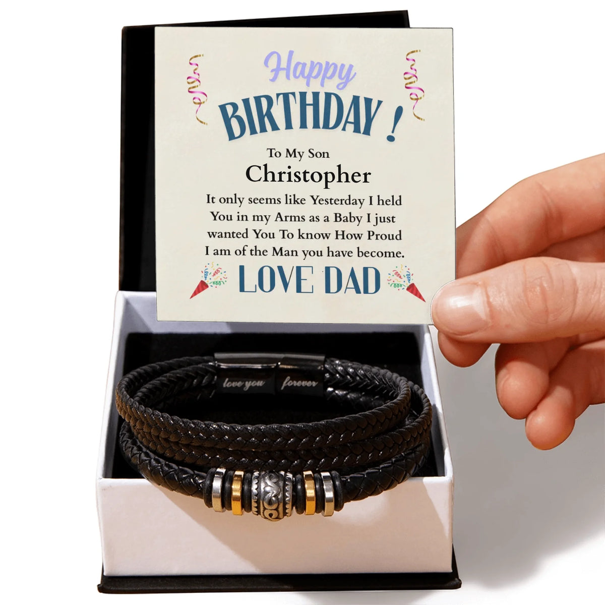Black leather bracelet with charms in a box with a birthday card for a son, held by a hand.