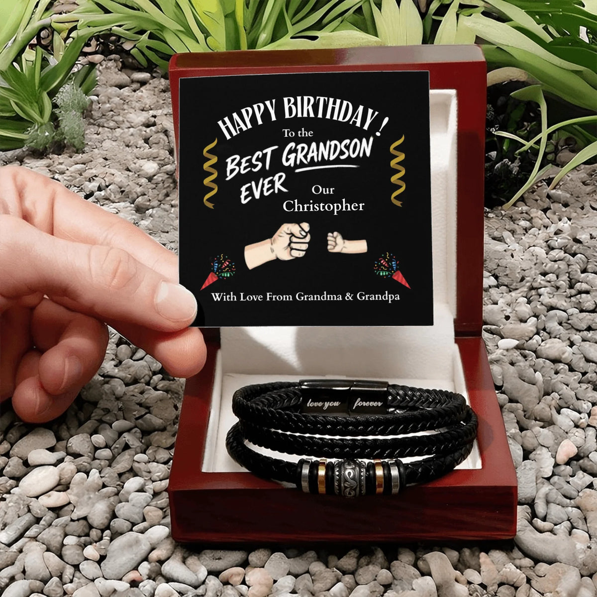 Personalized birthday gift for a grandson with leather bracelets in a wooden box, set against a natural stone background.