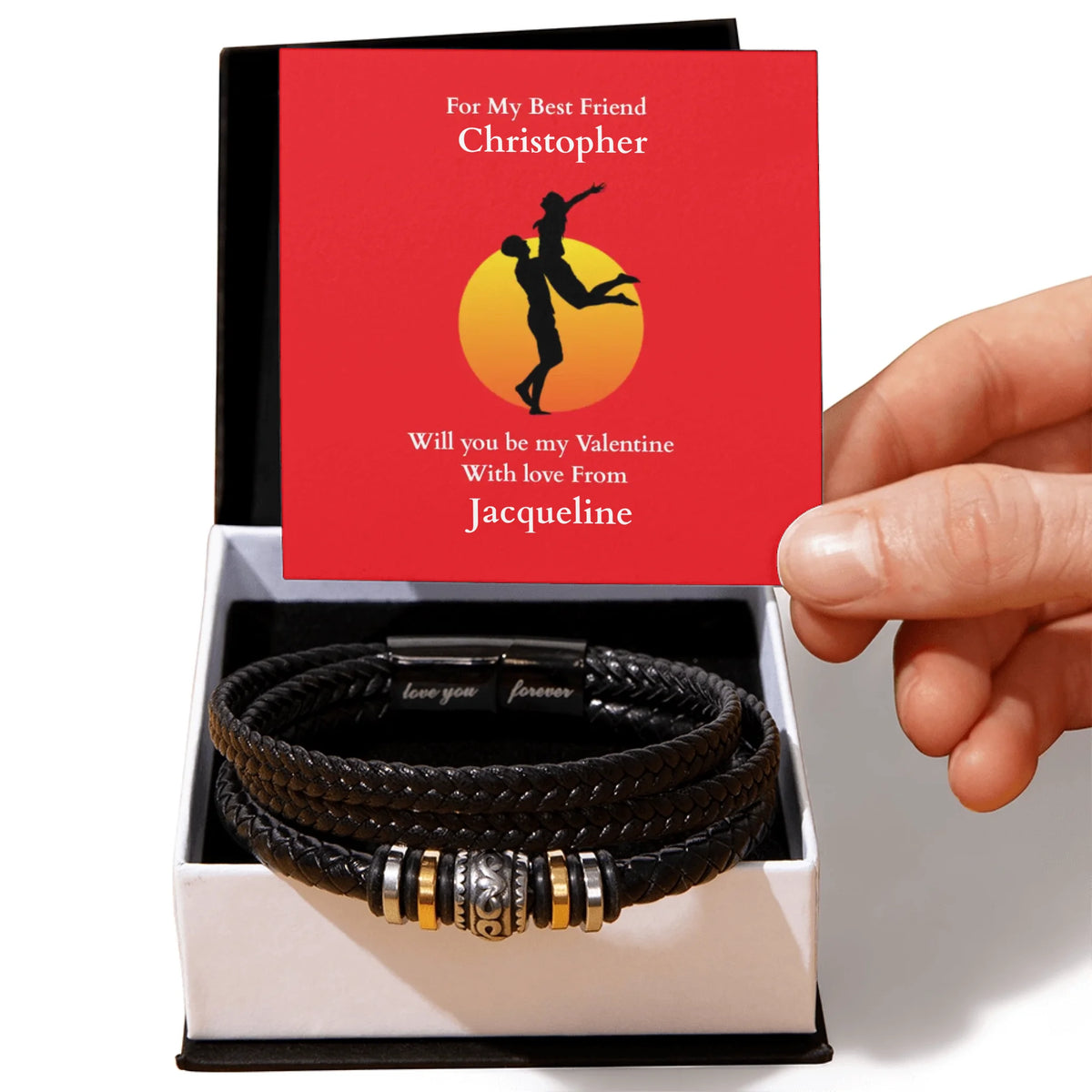 Black leather bracelet with metal charms in a box, featuring a personalized Valentine's Day card.