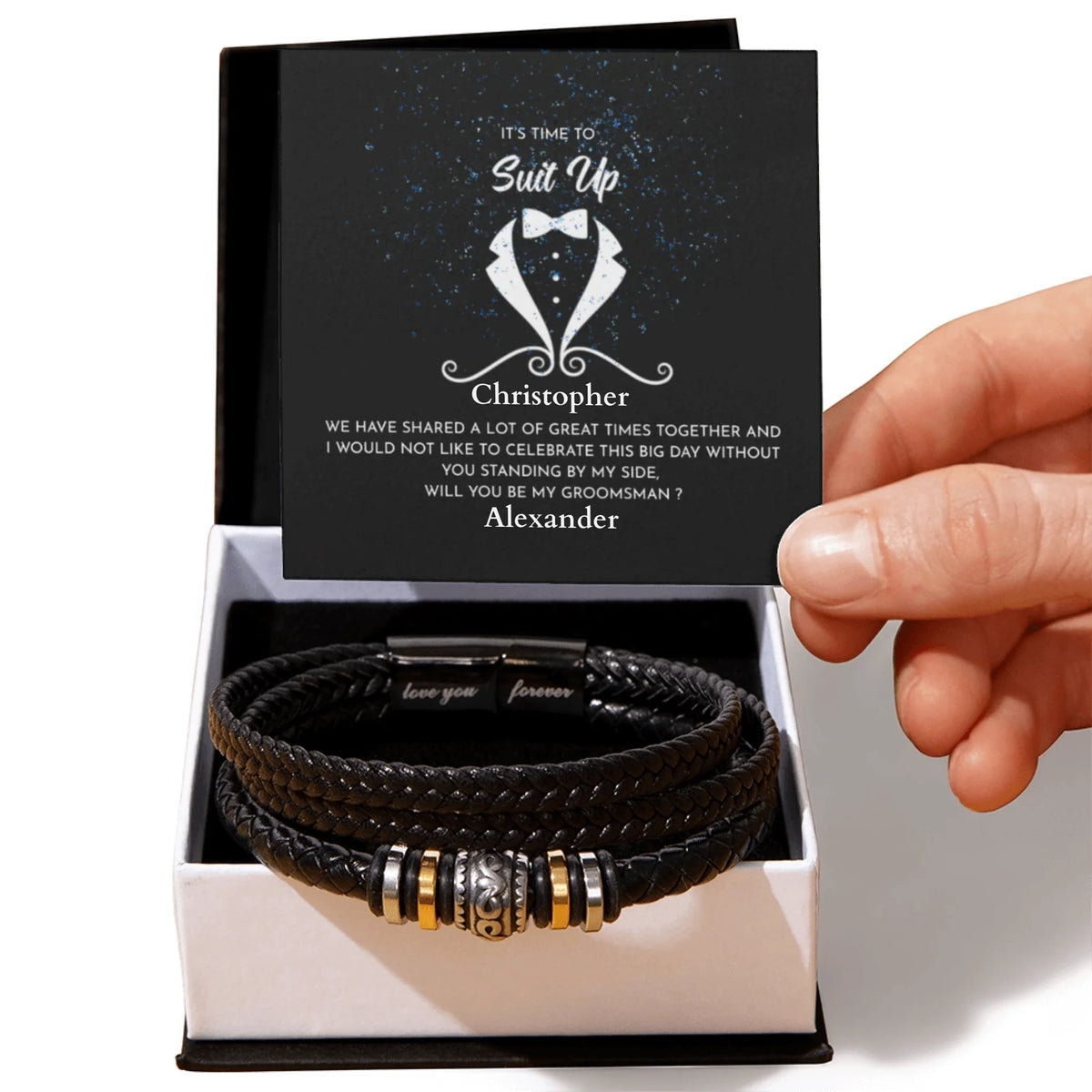 Black leather bracelet with engraved message in a box held by a hand